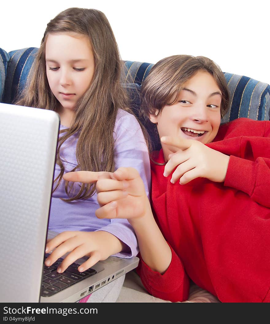 Brother and sister using laptop on the sofa