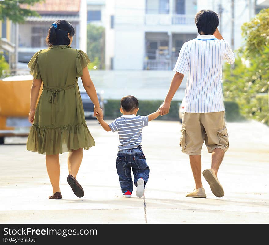 Parents holding hand of his son in outdoors