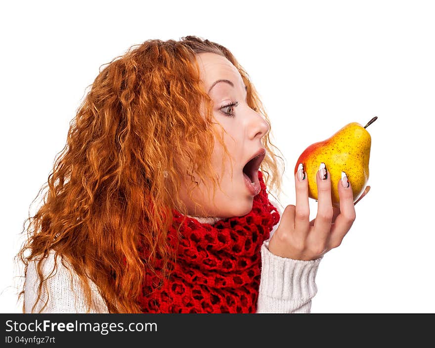 Redheaded girl wants to eat a pear isolated on white