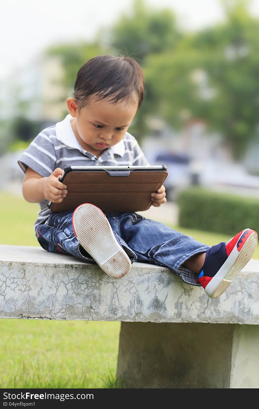 Little boy staring at a tablet