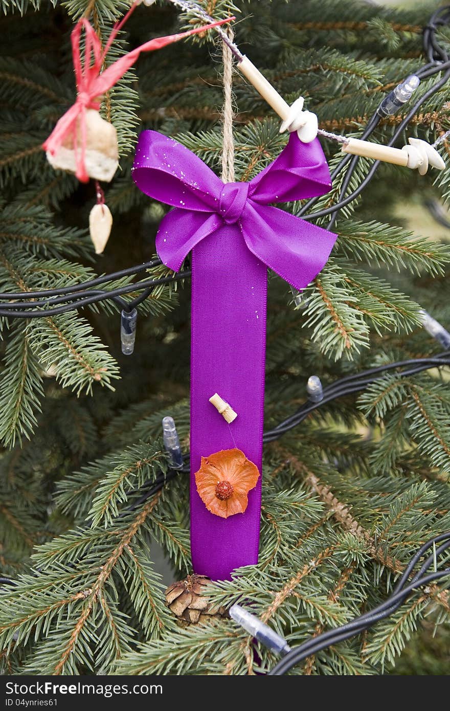 Christmas purple ribbon hanging on a spruce branch. Christmas purple ribbon hanging on a spruce branch