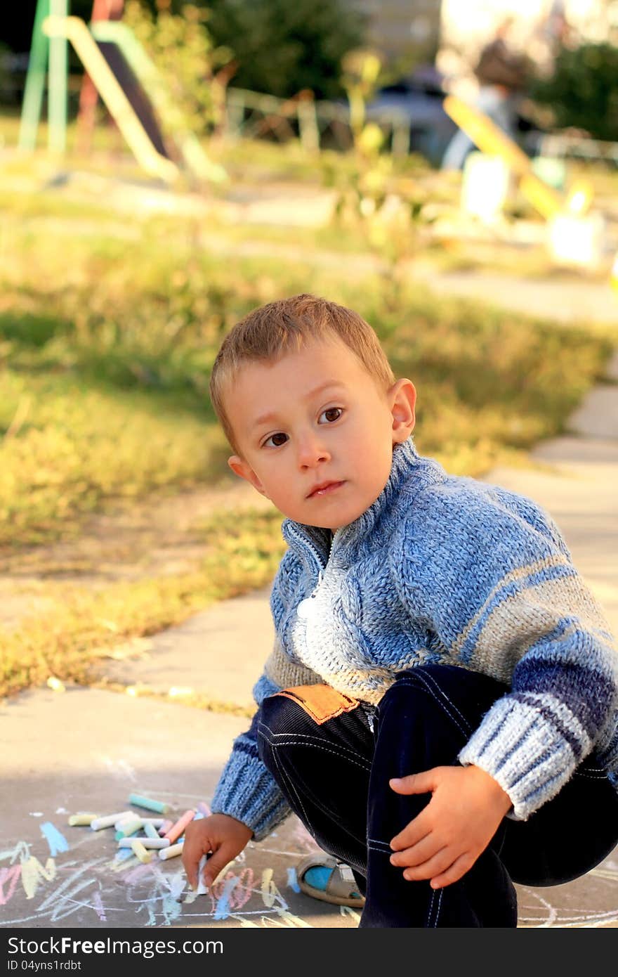 Portrait of the little lovely boy drawing with chalks. Portrait of the little lovely boy drawing with chalks