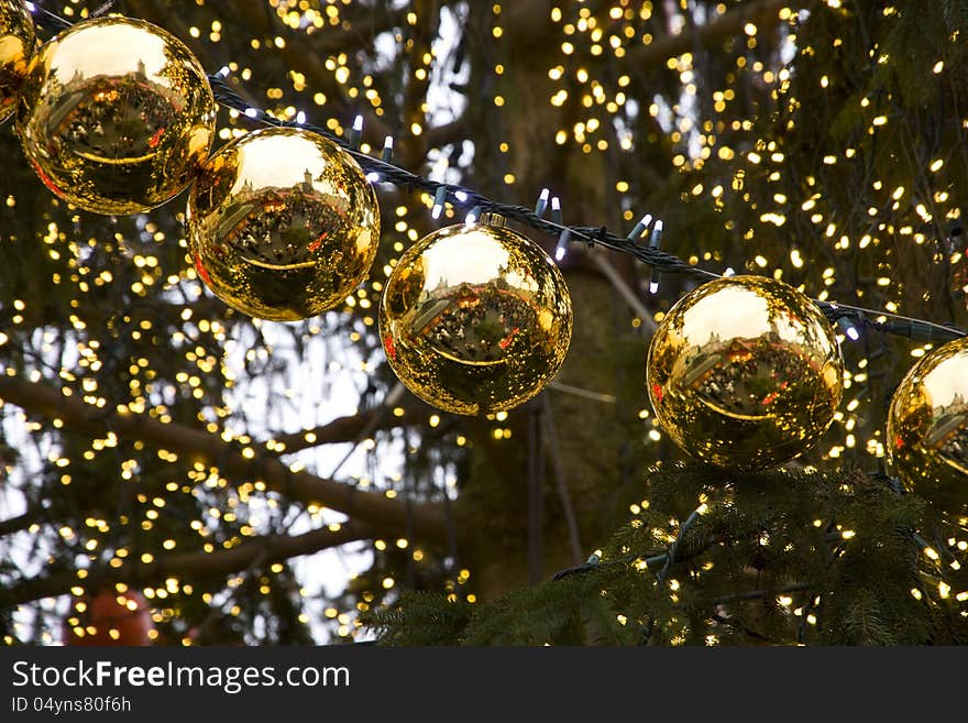 Golden christmas balls on the tree in a row