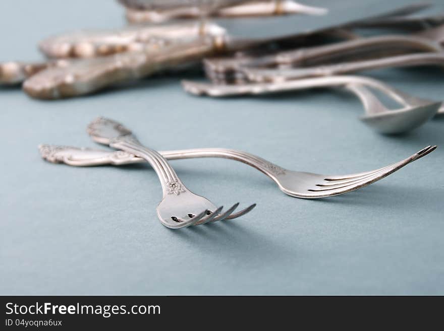 Retro style metallic forks and spoons on blue background. Retro style metallic forks and spoons on blue background.