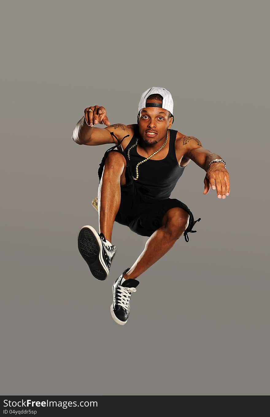 Hip Hop style dancer jumping isolated on a gray background