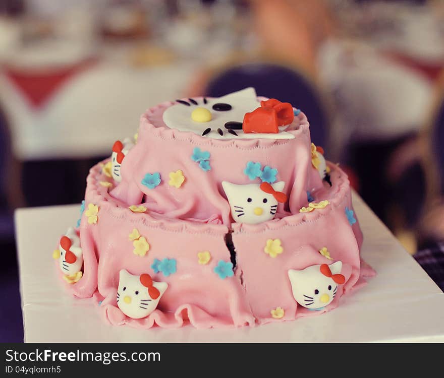 On a white background beautiful pink cake with muzzles cats. On a white background beautiful pink cake with muzzles cats