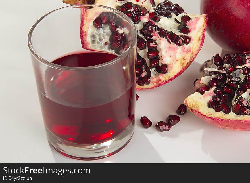 Tasty ripe pomegranate on a white background. Juice.