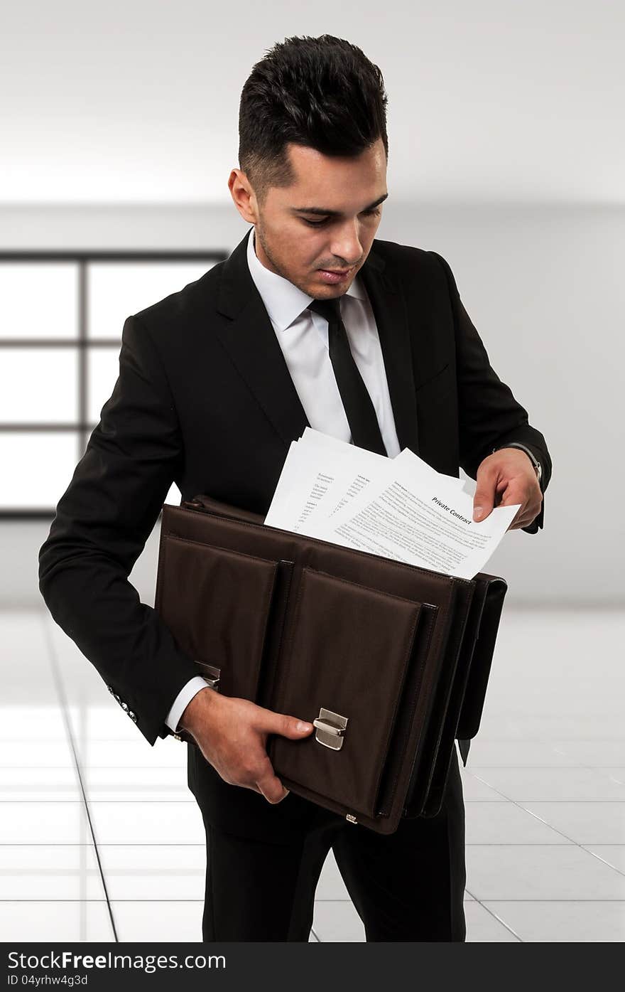 Businessman with a brown leather briefcase holding a contract  contract. Businessman with a brown leather briefcase holding a contract  contract