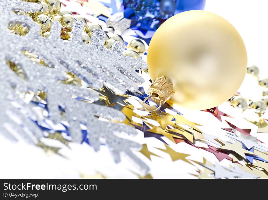 Christmas decoration collage on a white background with a decorative silver snowflake, colorful confetti in a star shape and Christmas balls.