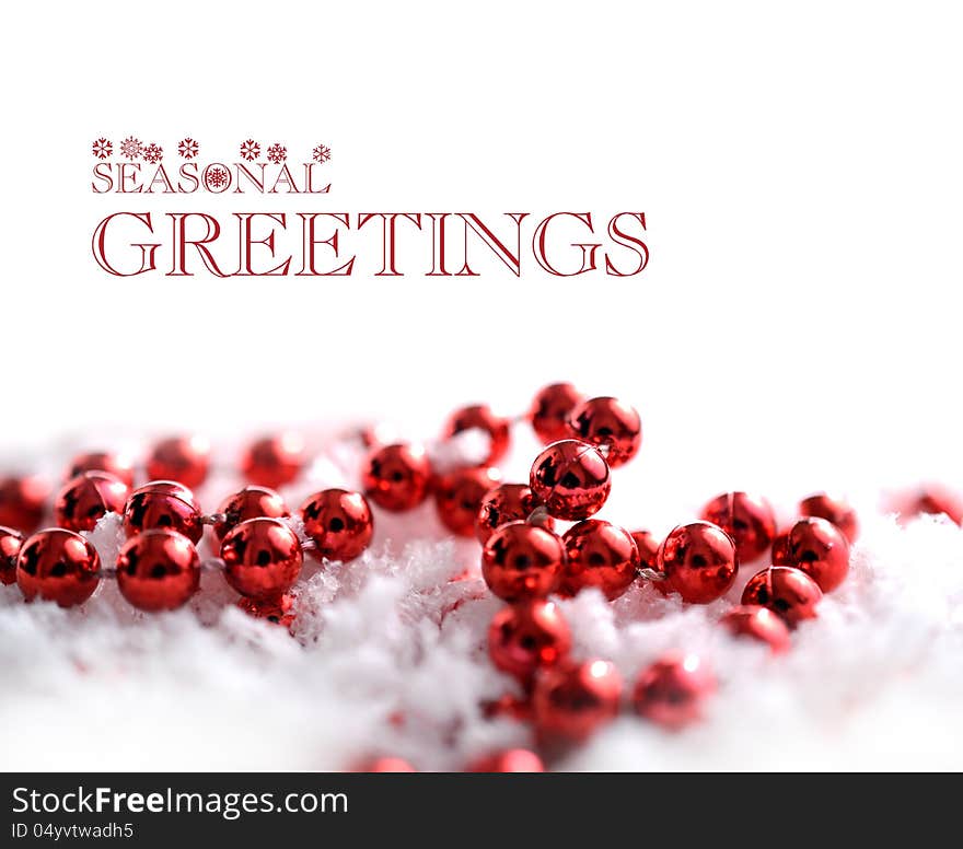 Studio macro image of red reflective decorative beads in soft snow flakes. Copy space. Studio macro image of red reflective decorative beads in soft snow flakes. Copy space.