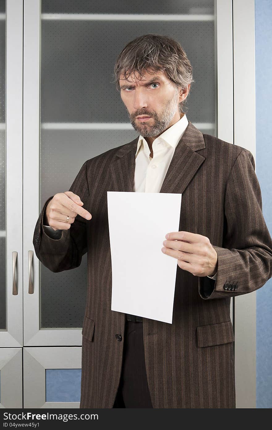 Angry man in business suit shows blanc sheet of paper. Angry man in business suit shows blanc sheet of paper