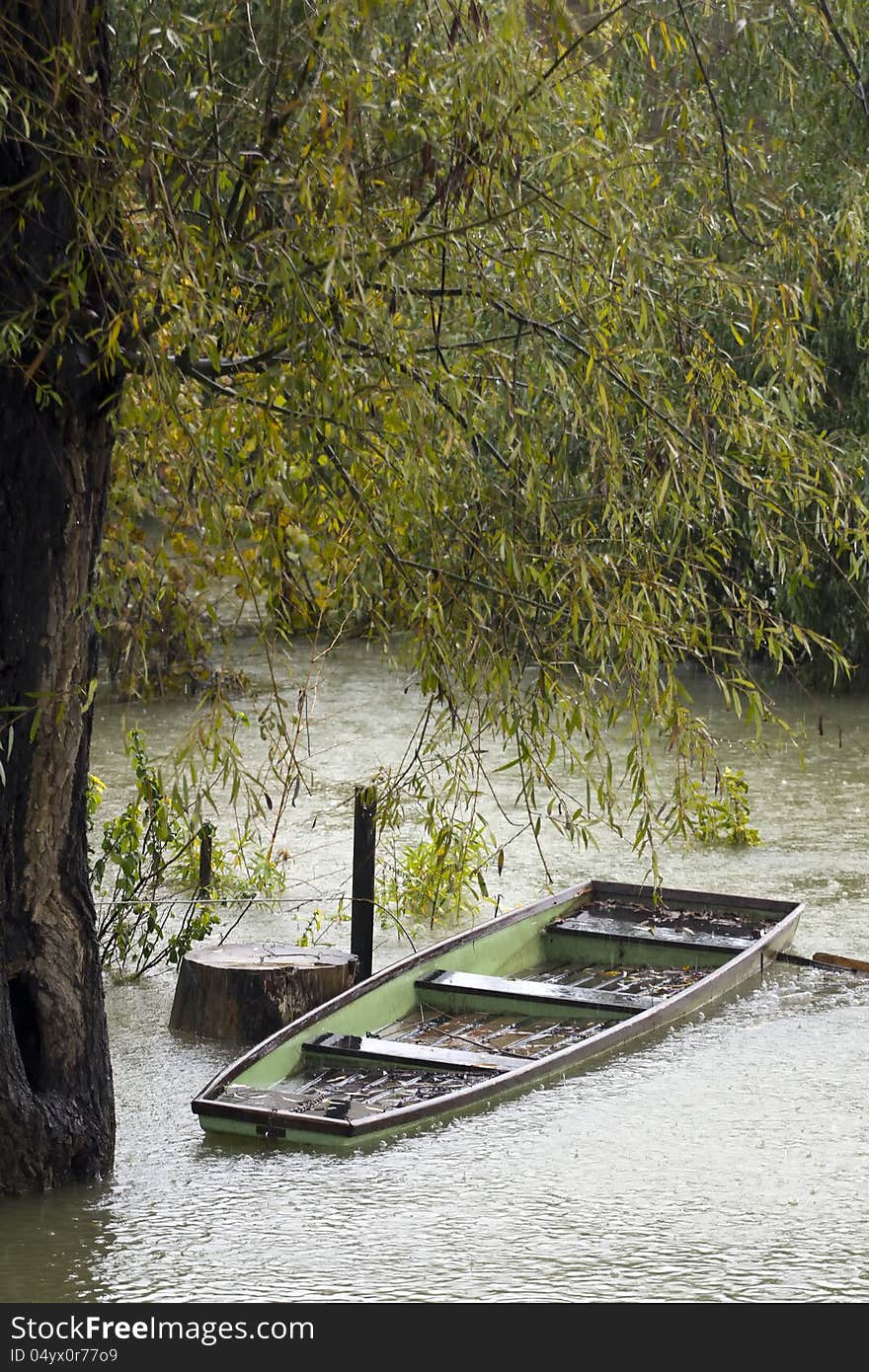 Wooden rowboat under heavy rain.