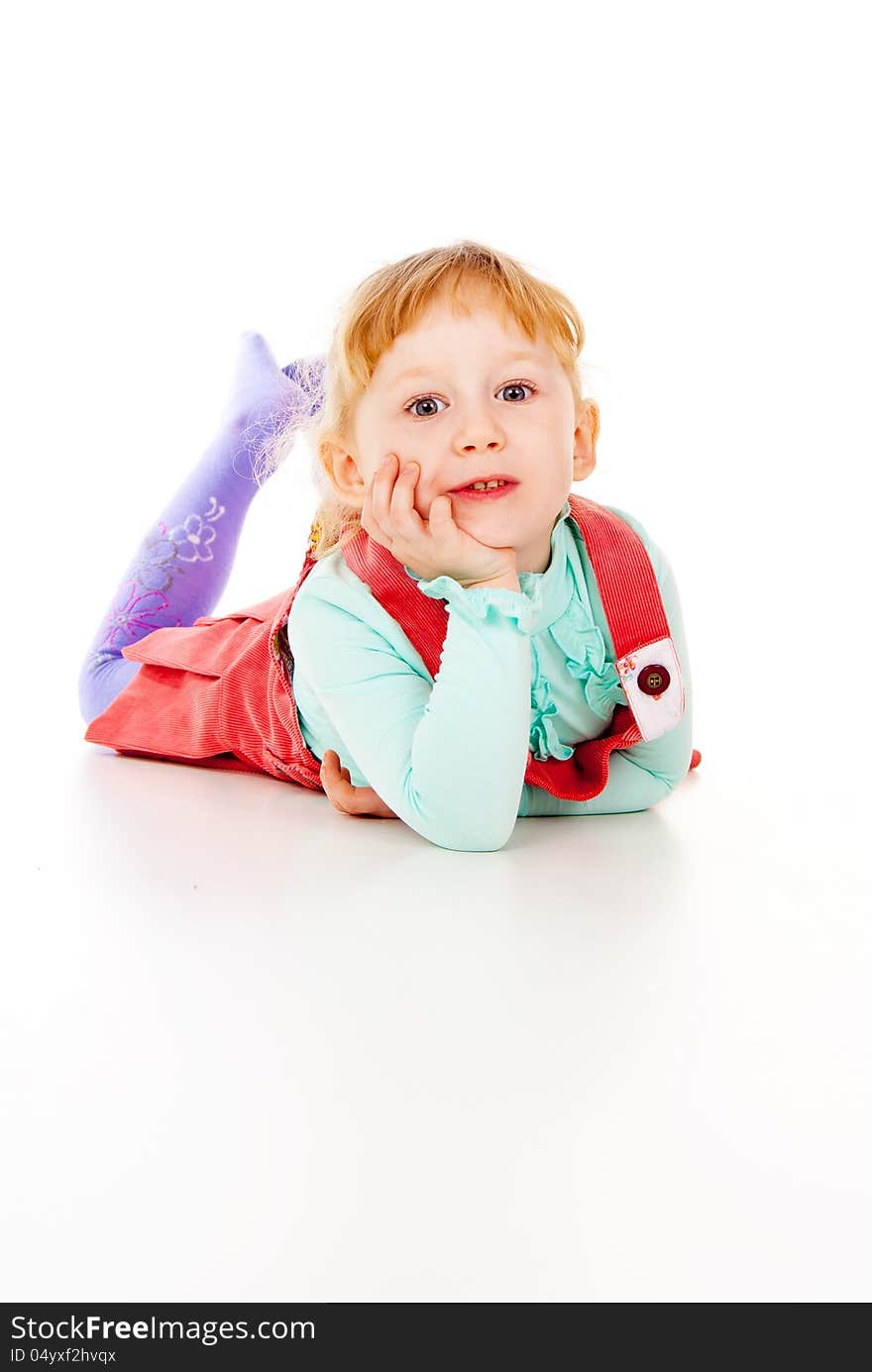 A little girl in a red dress, lying posing on white background