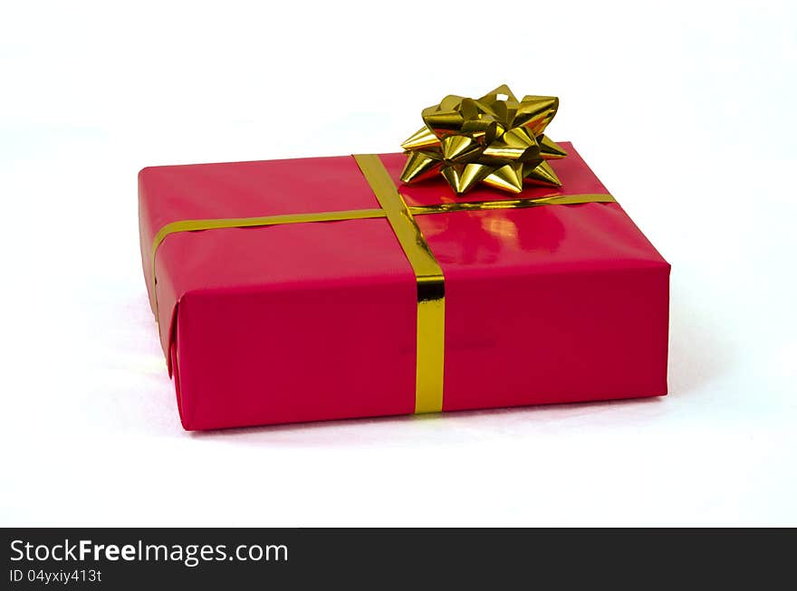 One single present packed in pink wrapping paper and  a ribbon isolated on white