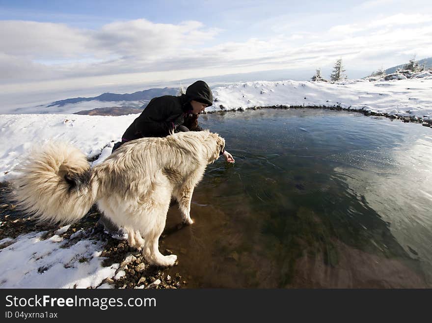 Woman with her dog in snowy mountain scenery