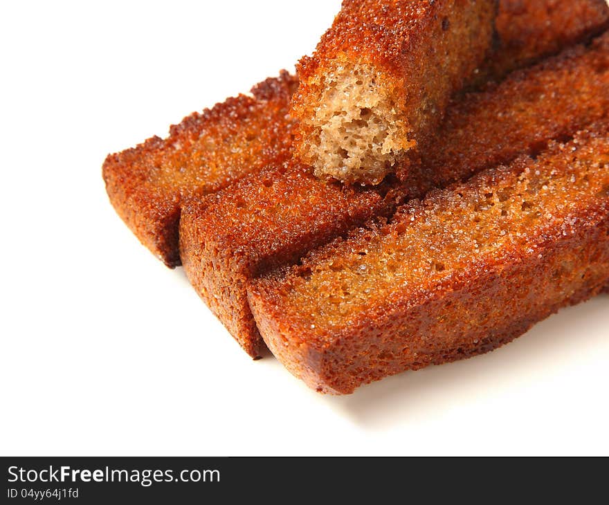 Three and half roasted croutons closeup on a white background