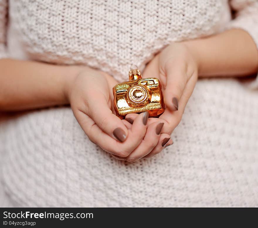 Woman's hands with manicure holding a Christmas toy golden