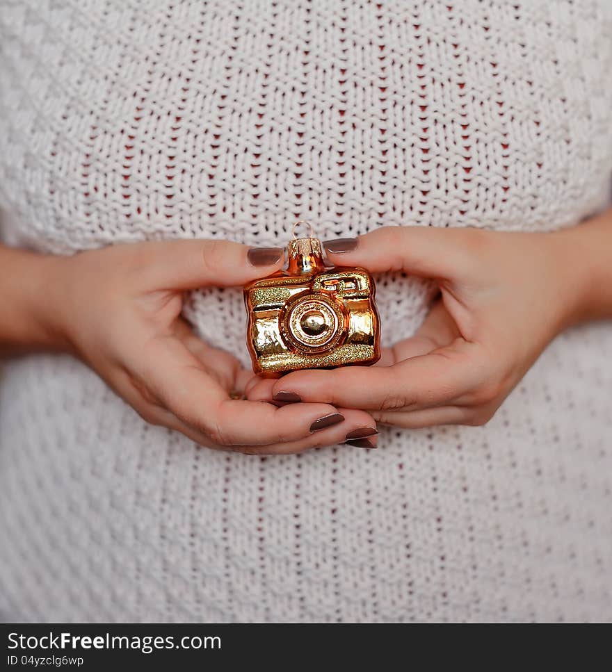 Woman's hands with manicure holding a Christmas toy golden