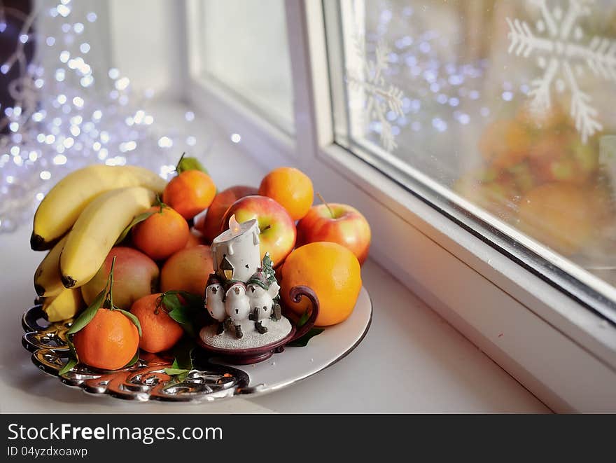 On the window still life fruit on a platter with a candle. On the window still life fruit on a platter with a candle