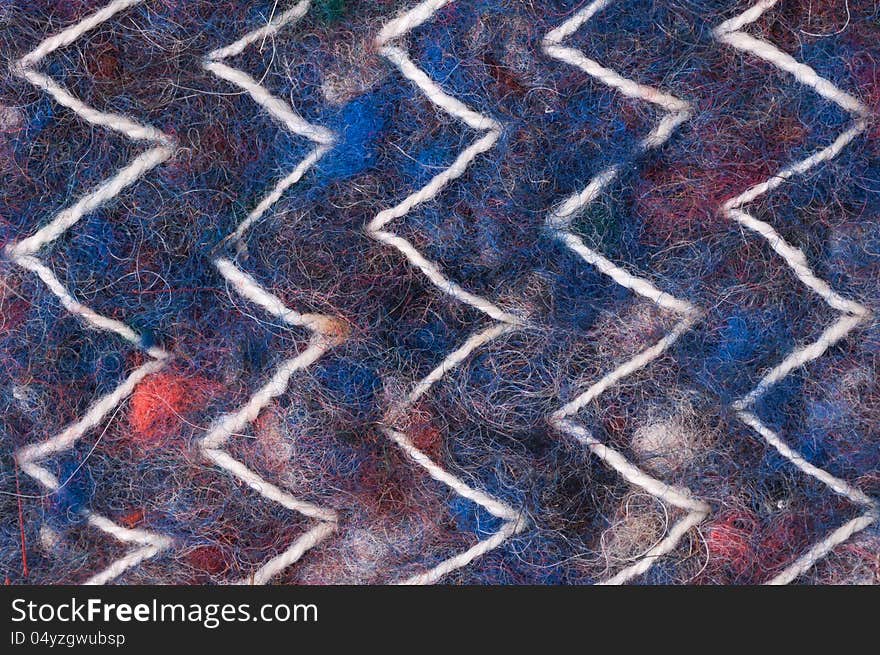 Colorful wool texture with white ornament close up