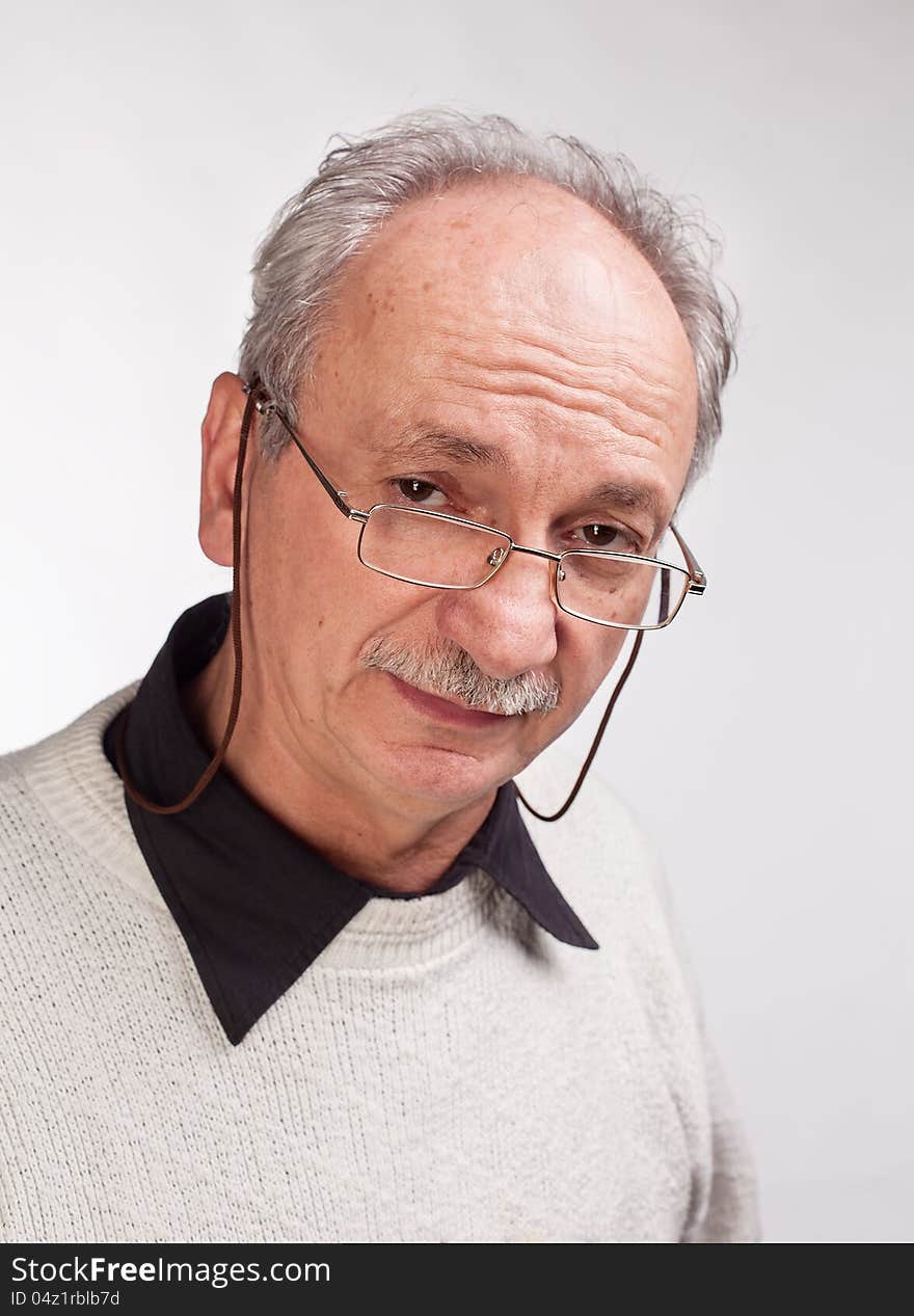 Portrait of a happy mature man with glasses and a white sweater