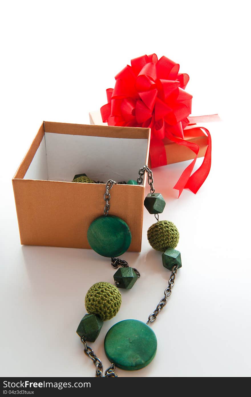 Gift box with red bow and green necklace