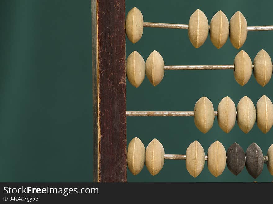 Old abacus fragment over green background