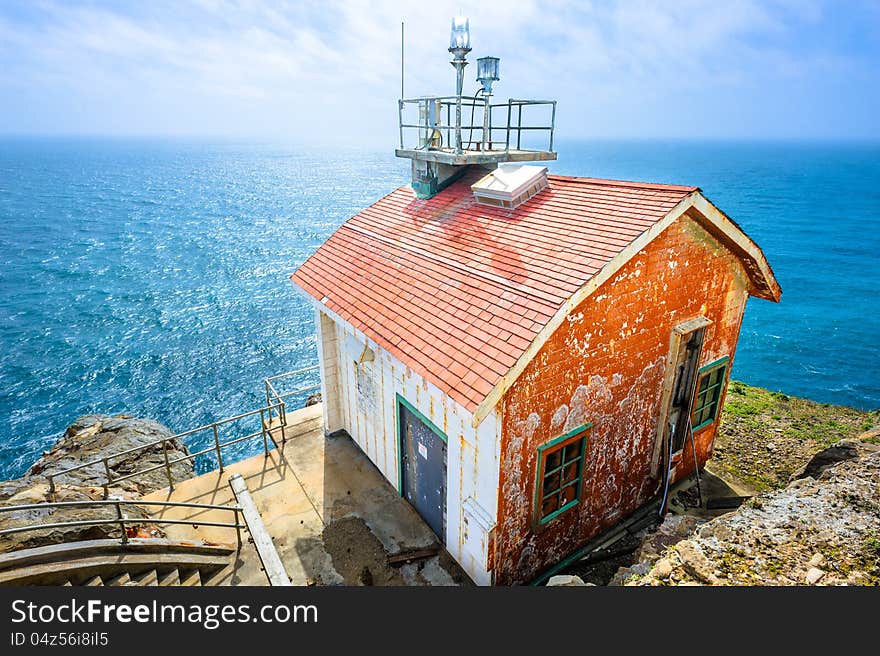 Old colorful beautiful house on the edge of the earth and the deep blue ocean behind. Old colorful beautiful house on the edge of the earth and the deep blue ocean behind