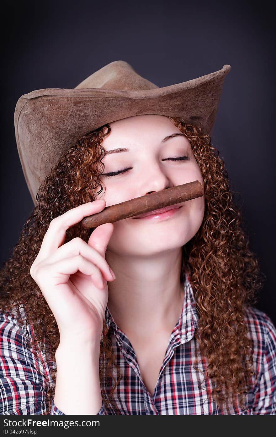 Pretty redhead girl smelling cigar