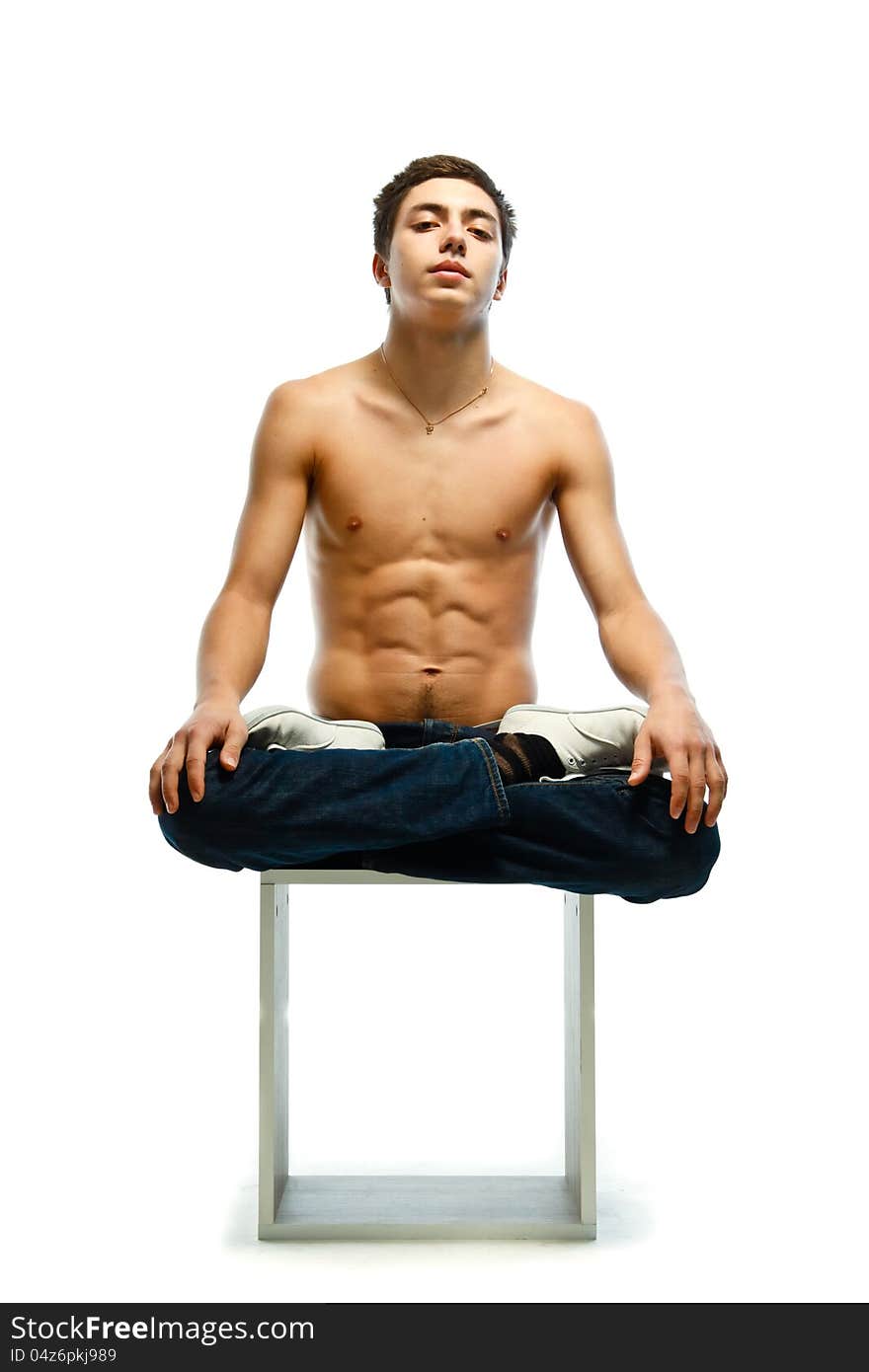 Athletic young man sitting in lotus pose  on white background