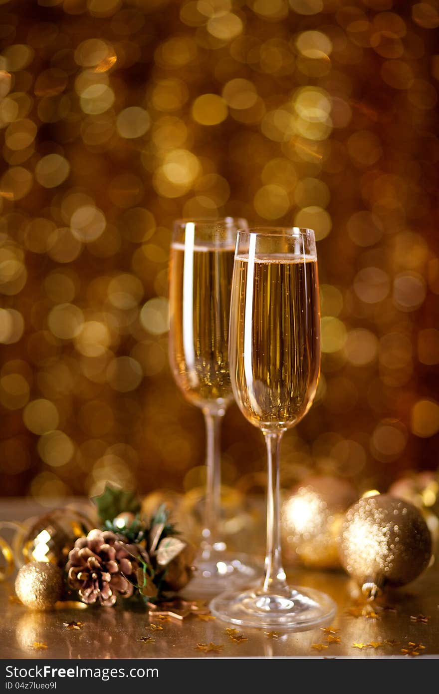 Two glasses of champagne with a Christmas decor in the background. very shallow depth of field, focus on near glass.