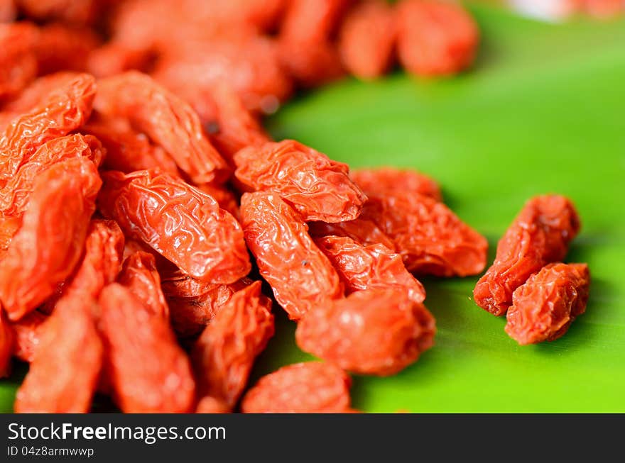 Dried Golgi Berry or Chinese Wolfberry (Lycium chinense) on green leaf background. Dried Golgi Berry or Chinese Wolfberry (Lycium chinense) on green leaf background.