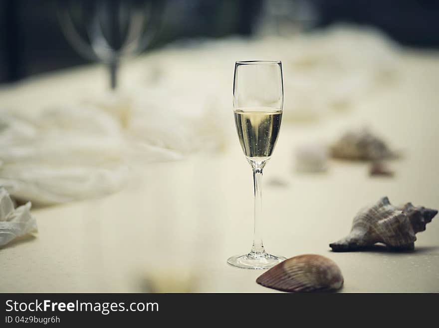 A glass of white wine on a wedding table with decorations. A glass of white wine on a wedding table with decorations