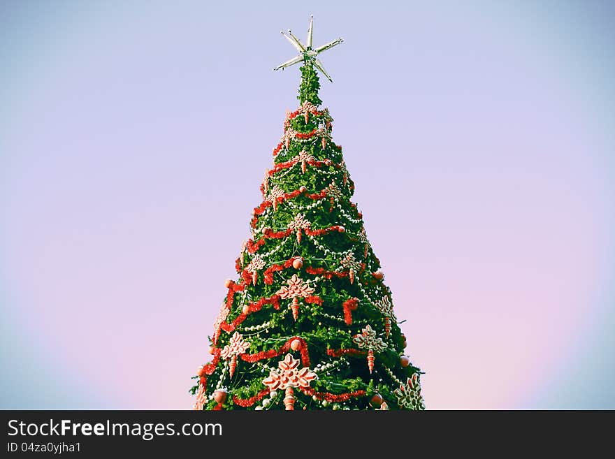 The christmas tree against abstract sky.