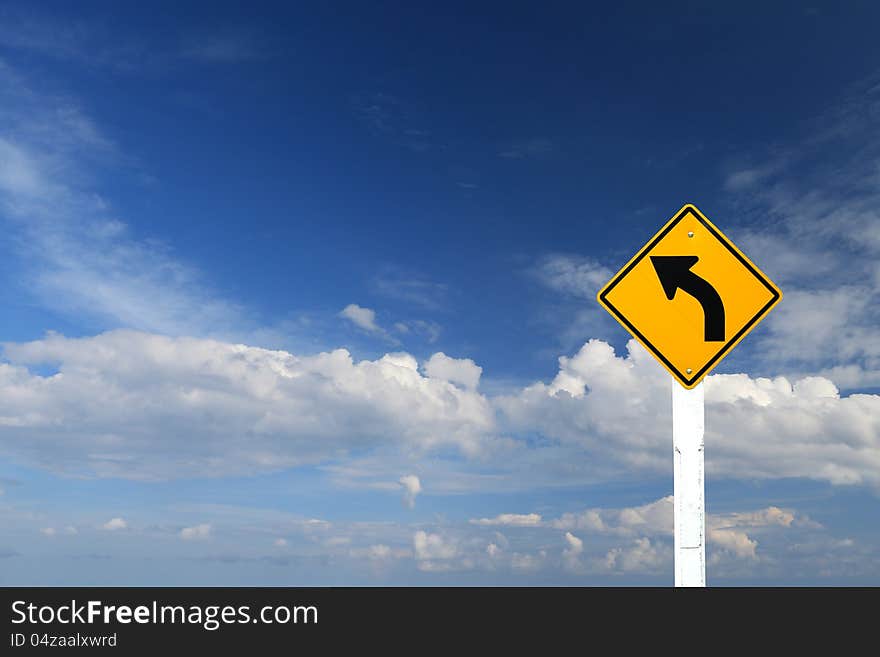 Direction sign- left turn warning on blue sky background with blank for text. Direction sign- left turn warning on blue sky background with blank for text