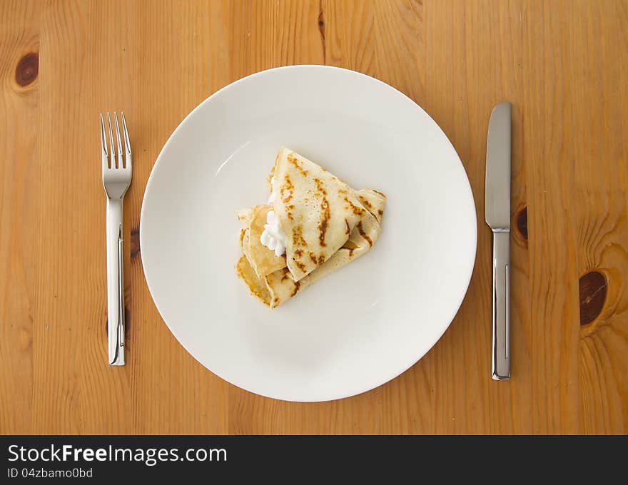 Top view on stuffed pancake on white plate