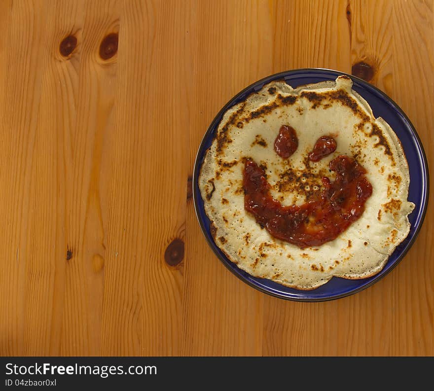 Top view on pancake with jam on blue plate