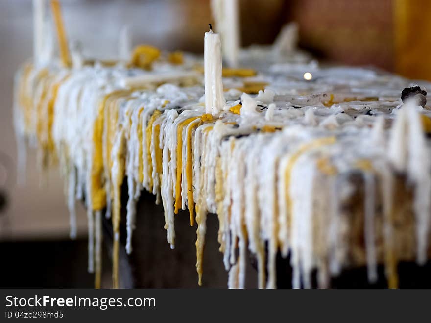 White and yellow dry candle tears hanging from the candle stand