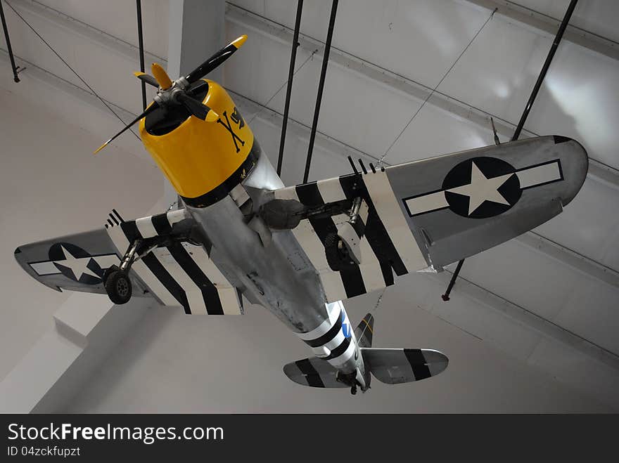 Vintage, historic, WW2 aircraft hanging from warehouse ceiling. Museum.