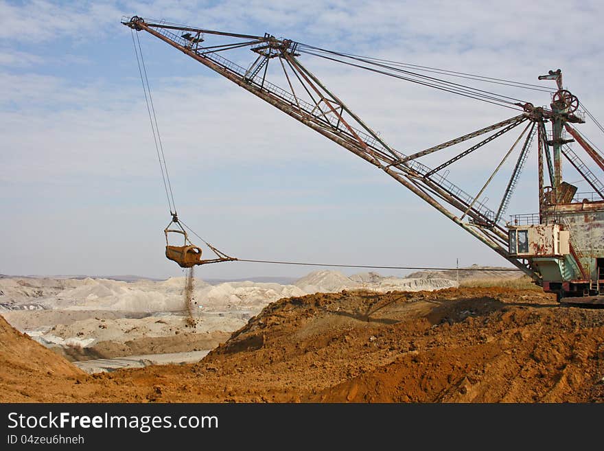 The powerful dredge digs a hole and transfers a ground to other place. The powerful dredge digs a hole and transfers a ground to other place