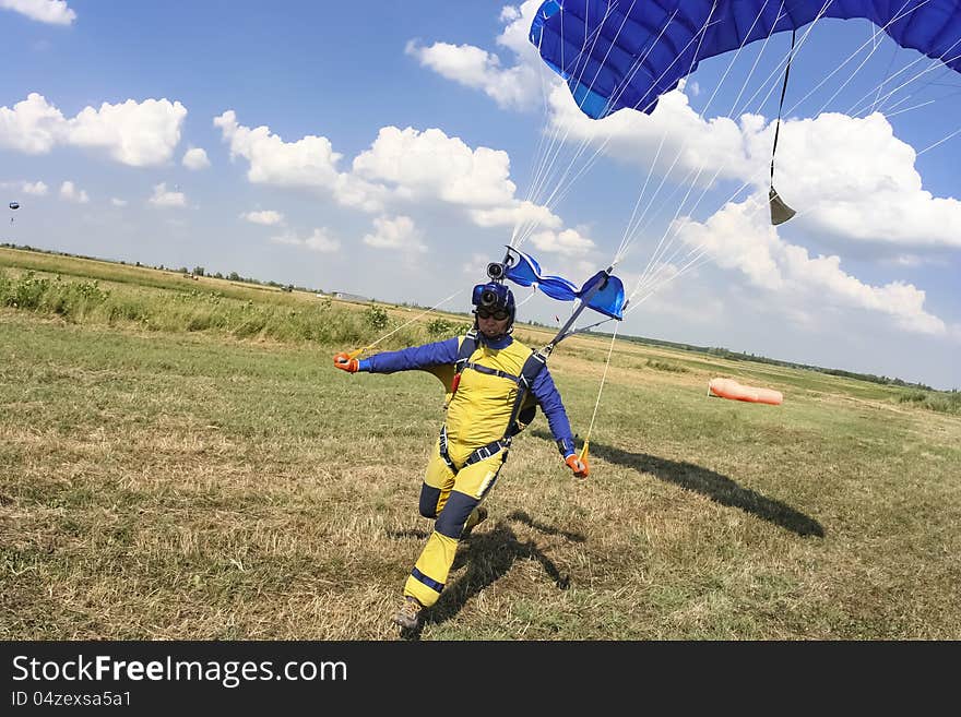 Parachutist lands on the ground. Parachutist lands on the ground.