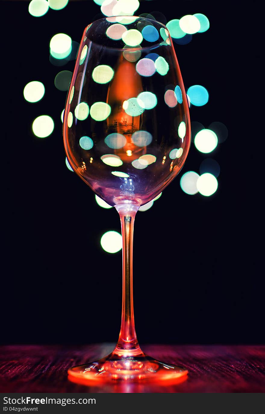 Empty wineglass on bokeh lights background