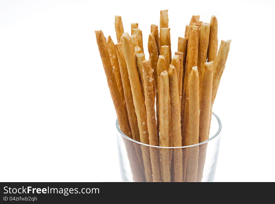 Bread sticks with salt in a glass beaker isolated on a white background