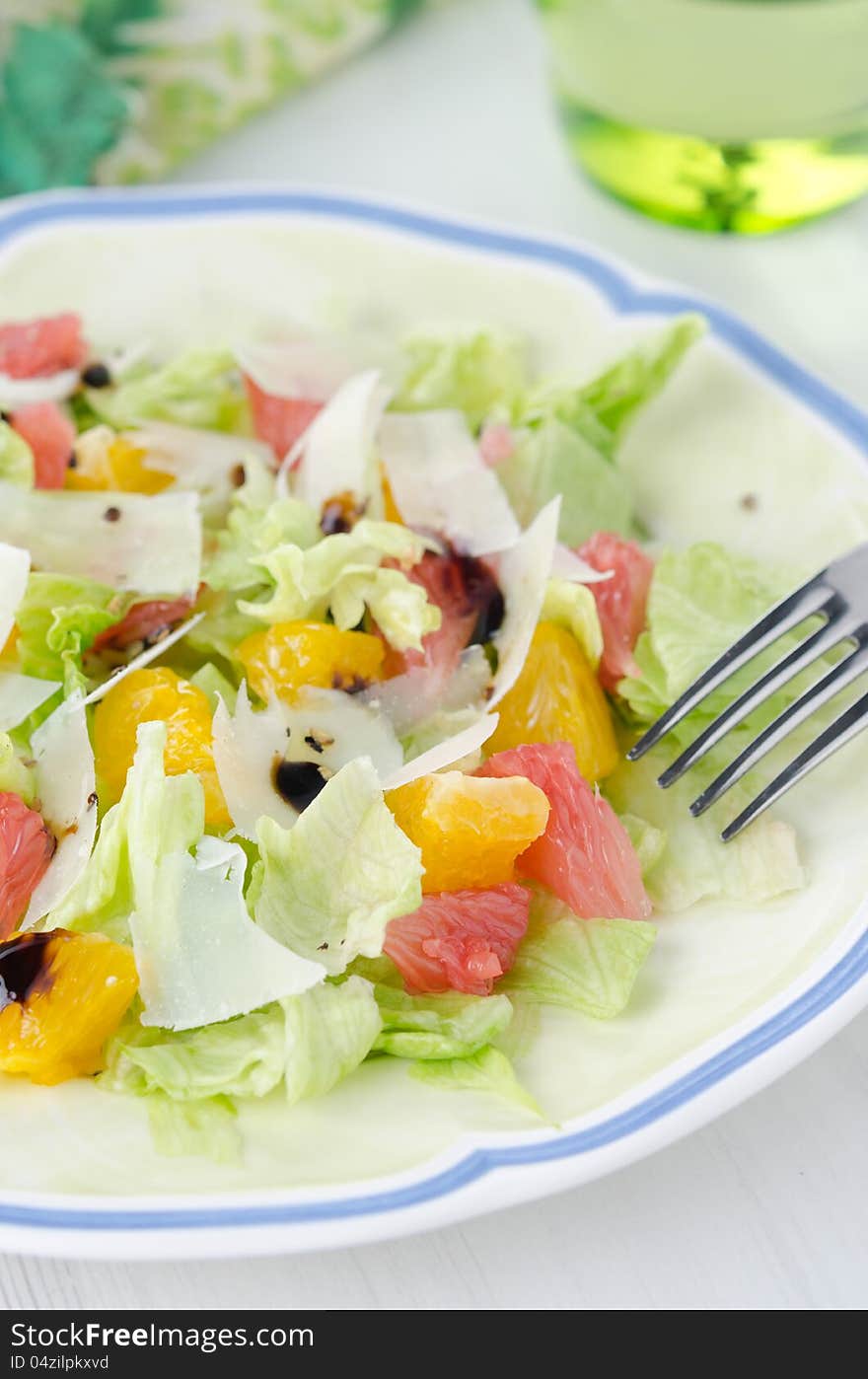 Salad with grapefruit, oranges, lettuce and cheese on a plate closeup. Salad with grapefruit, oranges, lettuce and cheese on a plate closeup