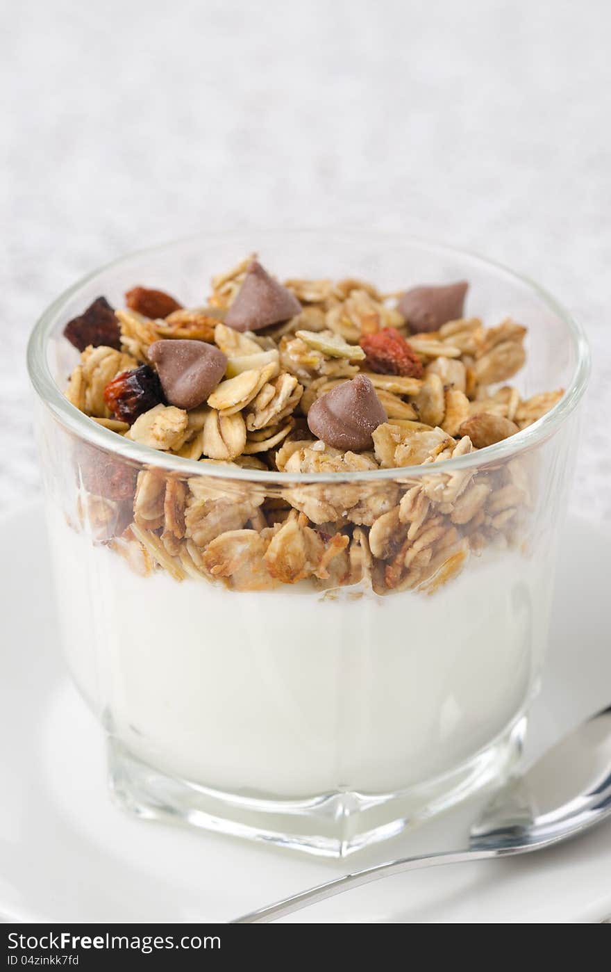 Yogurt with muesli and chocolate drops in a glass beaker of portion. Yogurt with muesli and chocolate drops in a glass beaker of portion