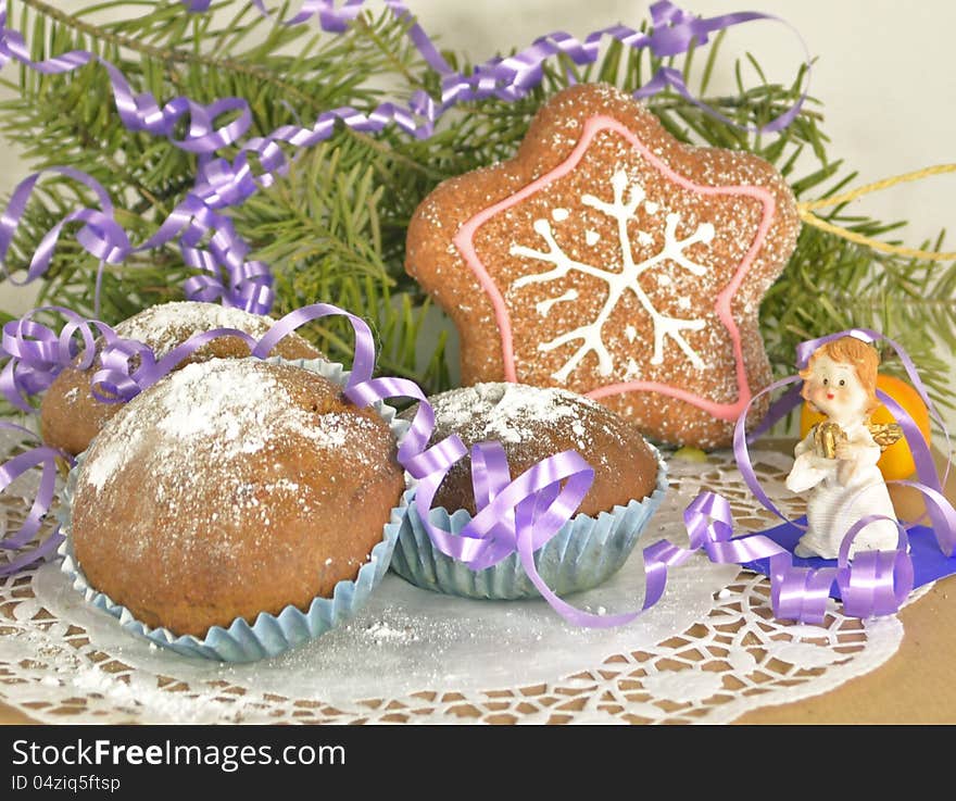 Three Christmas muffins with angel, purple ribbon and the conifer branch