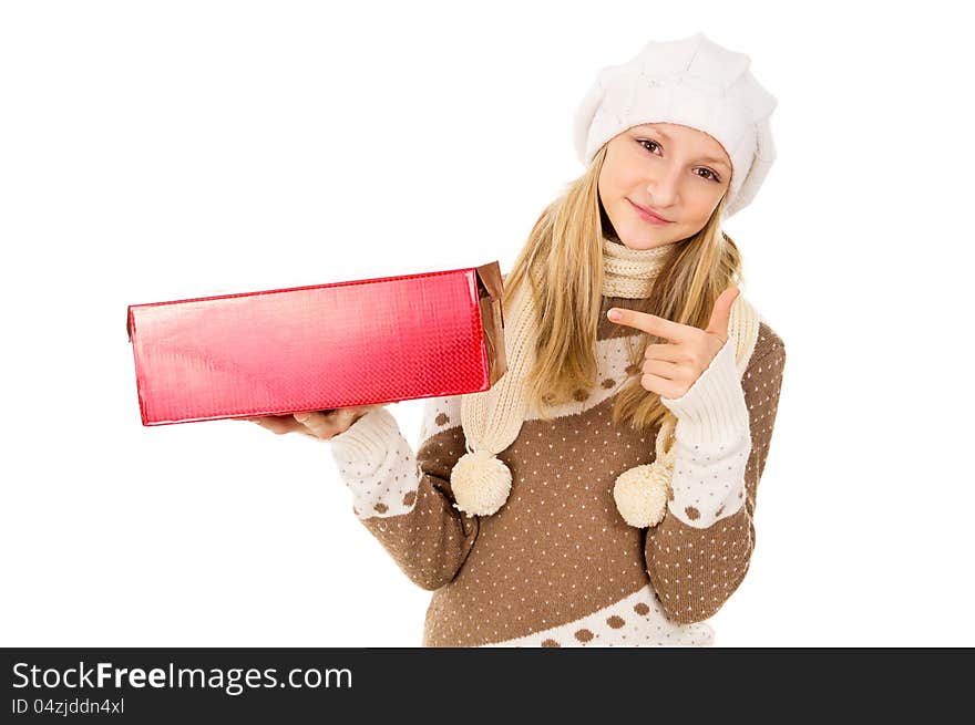 Girl in a winter cap points to gift. Girl in a winter cap points to gift