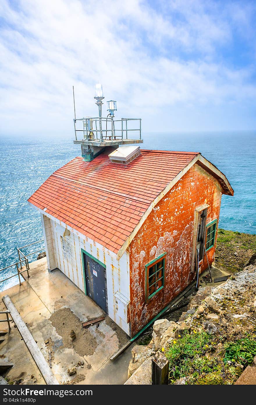 Old colorful beautiful house on the edge of the earth and the deep blue ocean behind. Old colorful beautiful house on the edge of the earth and the deep blue ocean behind