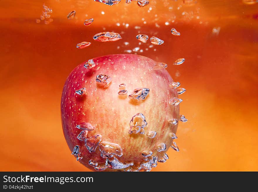 Red apple in water with some bubble