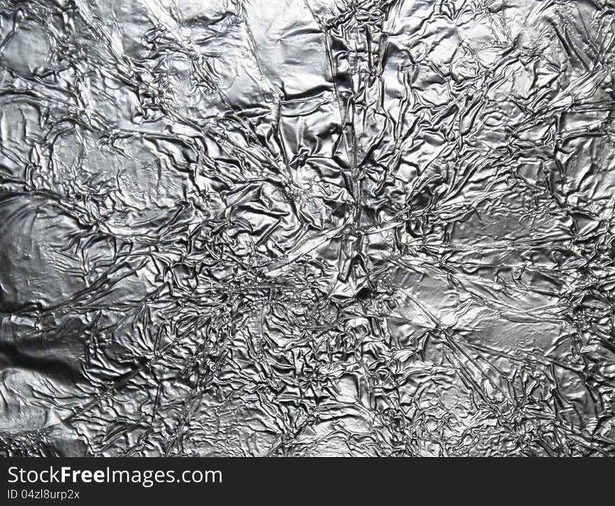 Silver crumpled foil surface background. Silver crumpled foil surface background